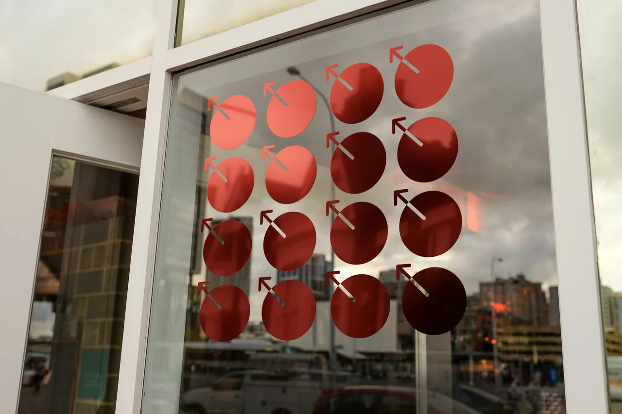 MetaDAO red identity marks on reflective storefront glass